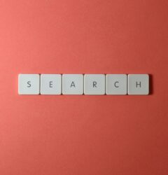 Teclado blanco con teclas que forman la palabra search sobre fondo rojo ilustrando la nueva guía oficial de Google AI Overviews