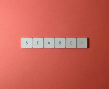Teclado blanco con teclas que forman la palabra search sobre fondo rojo ilustrando la nueva guía oficial de Google AI Overviews