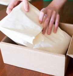 Persona preparando un pedido en caja de carton para vender en Amazon FBA como vendedor independiente