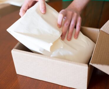 Persona preparando un pedido en caja de carton para vender en Amazon FBA como vendedor independiente
