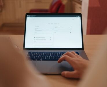 Un vendedor de comercio electrónico analiza gráficos financieros en su ordenador para calcular el presupuesto óptimo de Amazon Ads
